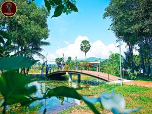 a bridge over a river with people walking on it at Ganesha Kampot Resort in Kampot