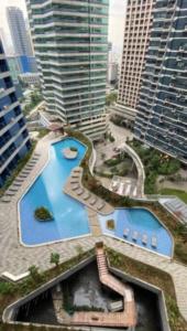 an overhead view of a pool in a city with tall buildings at Great View 1 BR Condo in Makati near Trident Tower in Manila