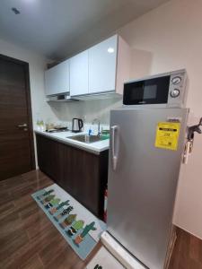 a kitchen with a white refrigerator and a counter top at Great View 1 BR Condo in Makati near Trident Tower in Manila