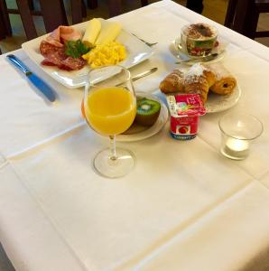 a table with a plate of food and a glass of orange juice at Hotel Pax in Luxembourg