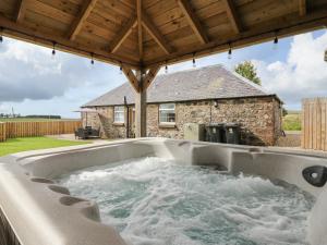 a jacuzzi tub in the backyard of a house at Sportsmans Lodge in Kirriemuir