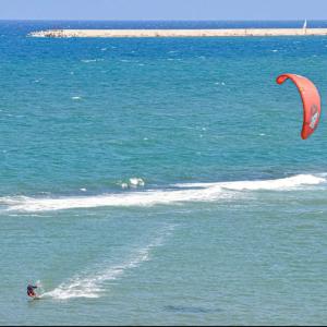 une personne fait du kitesurf dans l'océan dans l'établissement DOMUS RESIDENCE - CICERONE -, à Bari