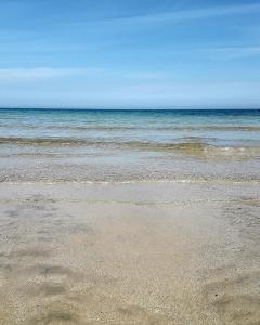 une plage de sable avec l'océan en arrière-plan dans l'établissement DOMUS RESIDENCE - CICERONE -, à Bari