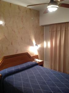 una camera con letto e piumone blu di Hotel Mitre a Rosario