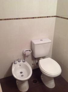 a bathroom with a toilet and a sink at Hotel Mitre in Rosario