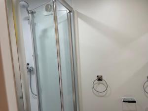 a shower with a glass door in a bathroom at THE LITTLE NEST BEACH sole use accommodation near to bath in Wick
