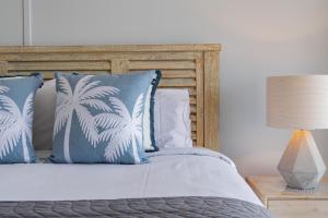 a bed with blue and white pillows and a lamp at Ocean View Studio 49A in Airlie Beach +55 photos