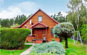 a wooden house with a tree and a swing at Amazing Home In Kopalino With 3 Bedrooms in Kopalino