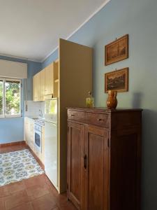 una cucina con pareti blu e un armadietto in legno di Casa Mirtina Ischia Sea House a Ischia