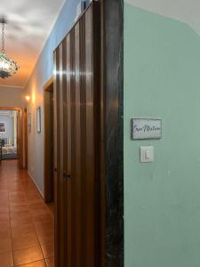 a hallway with a door and a sign on the wall at Casa Mirtina Ischia Sea House in Ischia