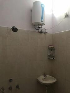 uma casa de banho com um lavatório e uma luz na parede em 9Backpackers Dehradun em Dehradun
