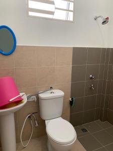 een badkamer met een wit toilet en een wastafel bij Teratak kasih homestay in Sandakan