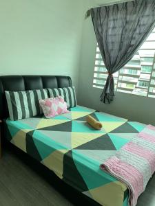 een slaapkamer met een kleurrijk bed en een raam bij Teratak kasih homestay in Sandakan