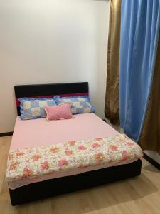 a bed with a pink pillow on top of it at Apartment Uno teratak kasih in Sandakan
