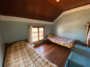 a bedroom with two beds and a window at Lycée Picot de Clorivière dont les revenus financent l'éducation des élèves in Antsirabe