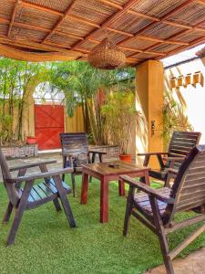 un grupo de mesas de picnic y sillas bajo un techo en La Guesthouse Étoile en Cotonú