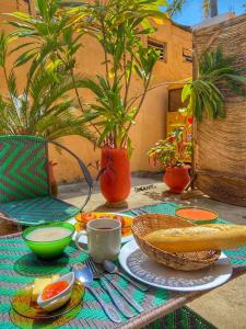 uma mesa com um prato de comida e uma tigela de pão em La Guesthouse Étoile em Cotonou