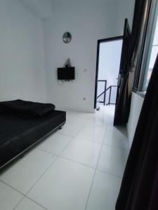 a black couch in a white room with a window at Rumah Kembar DI kawasan wisata lembang in Citeureup 1