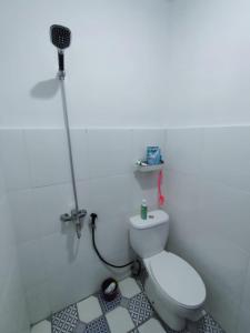 een badkamer met een wit toilet en een magnetron bij Rumah Kembar DI kawasan wisata lembang in Citeureup 1