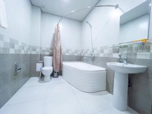 uma casa de banho com um lavatório, uma banheira e um WC. em Marakanda Hotel Samarkand em Samarkand
