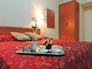 un vassoio con due tazze e frutta su un letto di Florida rooms - comfort Hotel a Roma