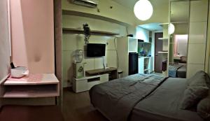 um pequeno quarto com uma cama e uma pequena cozinha em iRoom Margonda Residence 345 em Kemirimuka Tiga