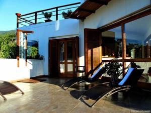 a patio with chairs and a house at Hospedaria Fascino Del Mare Guesthouse in Ilhabela