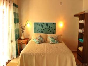 a bedroom with a bed with two pillows on it at Hospedaria Fascino Del Mare Guesthouse in Ilhabela +54 photos