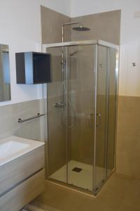 a shower with a glass door next to a sink at Appartamento AnnaChiara in Arco