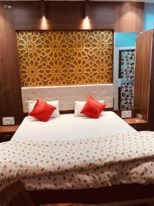a bedroom with a large bed with red pillows at Hotel Nishi in Balasore