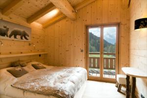 ein Schlafzimmer mit einem Bett und einem großen Fenster in der Unterkunft Hevea in Chamonix-Mont-Blanc