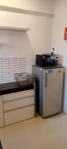 Villa at Lonavala - SaGa Montana (Hill View) في لونافالا: مطبخ مع ثلاجة صغيرة وكاونتر