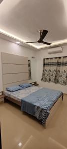 Villa at Lonavala - SaGa Montana (Hill View) في لونافالا: غرفة نوم بها سرير ومروحة سقف