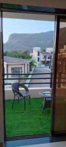Villa at Lonavala - SaGa Montana (Hill View) في لونافالا: اطلالة على شرفة مع كرسيين وطاولة +18 صورة