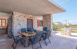 a dining room with a table and chairs on a patio at Nice Home In Sibenik With Wifi And 2 Bedrooms in Šibenik