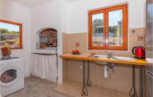 a kitchen with a sink and a washing machine at Nice Home In Sibenik With Wifi And 2 Bedrooms in Šibenik