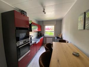 a kitchen with red cabinets and a wooden table at Brockenblick in Braunlage