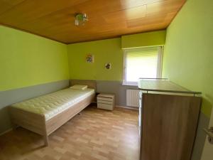 布勞恩拉格的住宿－Brockenblick，一间位于绿色客房内的卧室,配有一张床