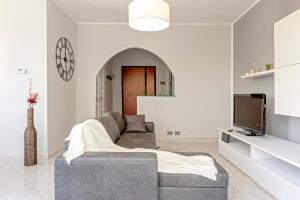een woonkamer met een bank en een tv bij [FREE PARKING] Appartamento 5 STELLE elegante con suite in Livorno