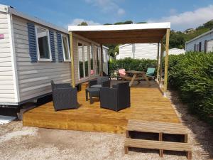 a deck with chairs and a table on a tiny house at Mobilhome2frejus in Fréjus