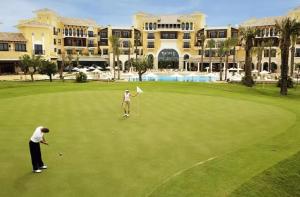 two people playing golf in front of a resort at Villa Fresno with Private Pool on gated 5* Mar Menor Golf Resort - 3 Bed/3 shower/WC in Torre-Pacheco