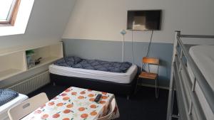 a small room with two bunk beds and a table at Pension Zevenbergen in Zevenbergen