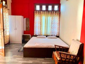 迪布魯加爾的住宿－J&B Homestay，一间卧室设有一张大床和一个窗户。