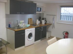a kitchen with a washing machine and a sink at Main-Kinzig Gästewohnung in Hasselroth