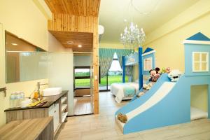 - une salle de bains pour enfants avec toboggan au milieu de la chambre dans l'établissement Fairy Story Village Farm B&B, à Dongshan