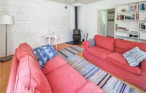 sala de estar con sofá rojo y chimenea en Amazing Home In Frgelanda With Kitchen, en Färgelanda