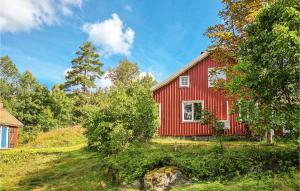 un granero rojo en una colina con árboles en Amazing Home In Frgelanda With Kitchen, en Färgelanda