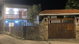 een huis met een houten poort en een stenen muur bij Mar y Montaña - casa completa finca privada in Lamuño