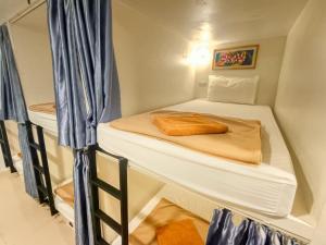 a small room with two bunk beds in it at Jomtien Beach Hostel in Jomtien Beach