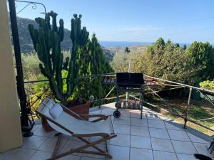 einen Balkon mit einem Stuhl, einem TV und einem Kaktus in der Unterkunft Ca' Clémentine in Sasso di Bordighera